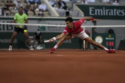 El serbio Novak Djokovic se estira para devolver la pelota al español Rafael Nadal. 