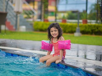 Una niña disfruta de la pisicina.