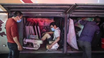 Un hombre viaja en el compartimento de equipaje de un autobús, en Shangyong (China).