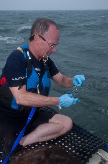 El científico Jeff Short instala uno de los detectores de contaminación para lanzarlo al agua desde el buque 'Oceana Latitude'