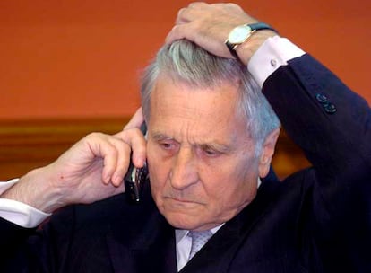 El presidente del BCE, Jean-Claude Trichet, atiende una llamada en su móvil antes de su conferencia en Budapest (Hungría).