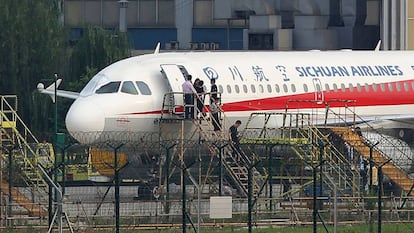 Técnicos revisan el avión de Sichuan Airlines que sufrió un accidente en la cabina.