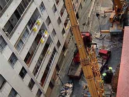 Las grúas levantan los vagones siniestrados a través de las perforaciones realizadas en la calle sobre el metro.