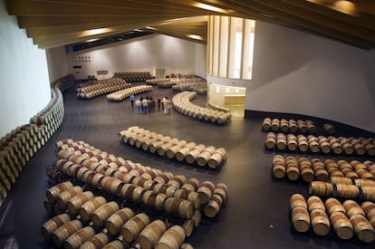 Una visita guiada permite recorrer la sala de barricas de la bodega Ysios, en cuyo interior también quedan subrayadas las líneas sinuosas que caracterizan el proyecto.