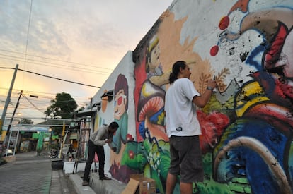 El artista urbano indonesio X-Go, en un momento de la elaboración de un mural en el Kampung Lakarsantri, con su equipo, en Surabaya, en 2014.