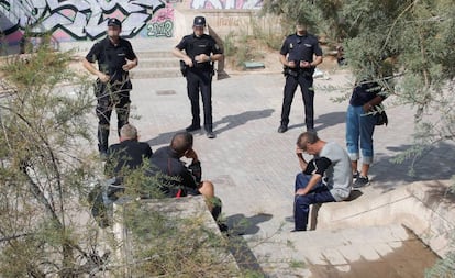 Agentes de policía custodian a los cuatro indigentes, en calidad de testigos, que compartían lugar de pernoctación con el indigente hallado muerto bajo un puente en Teulada. 