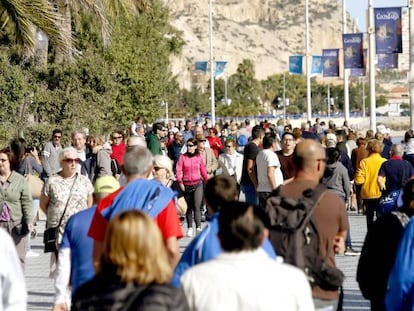 Turistas en el paseo mar&iacute;timo de la playa de El Postiguet (Alicante)