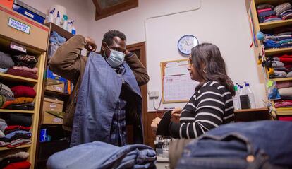 Un joven migrante comprueba la talla de unos pantalones en un centro de acogida de Irún.