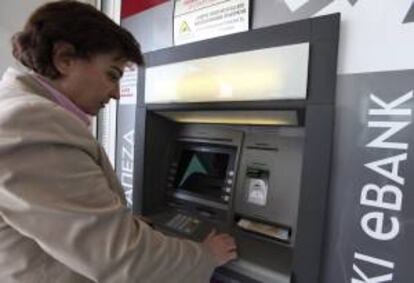 Una mujer saca dinero ayer de un cajero automático en Nicosia, Chipre.