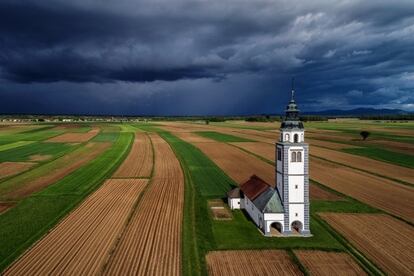 Iglesia de Santa Úrsula en medio de los campos de Sorško, cerca de la ciudad eslovena de Kranj, justo antes de una tormenta de primavera.