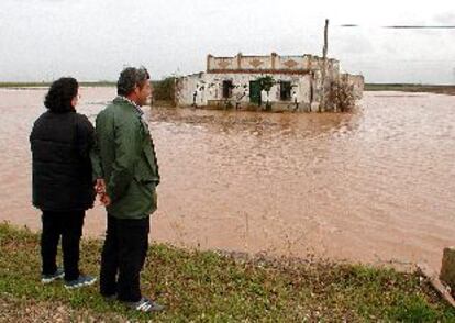 Vecinos de Cantillana (Sevilla) observan el desbordamiento del Guadalquivir, que ha anegado sus viviendas.