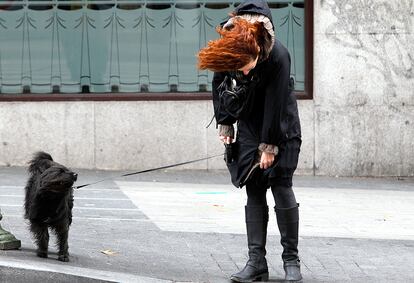 Una mujer y su perro soportando el temporal de viento en los alrededores de Plaza de España, de Madrid