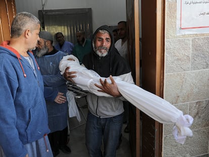 The wrapped body of nine-year-old Mohammed Awad is carried by his grandfather at Nasser hospital in Gaza