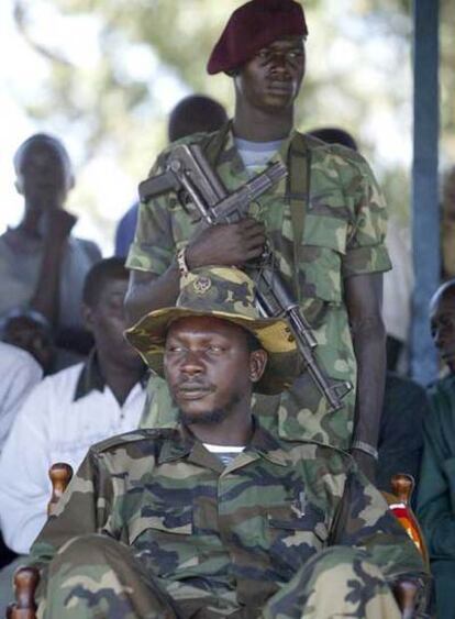 Thomas Lubanga (sentado), en Bunia (Congo), en 2003, protegido por un guardaespaldas.