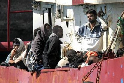 Varios inmigrantes asiáticos esperan su desembarco en el puerto de Santa Cruz de Tenerife.