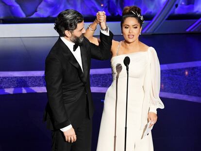 Salma Hayek sujeta el brazo de Oscar Isaac sobre el escenario de los Oscar.