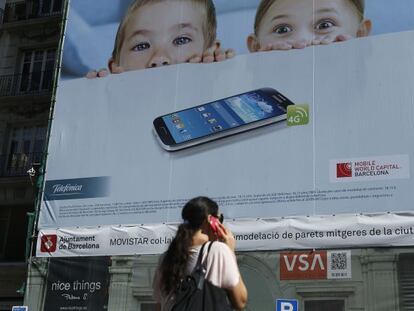 Una mujer habla por su m&oacute;vil en una calle de Barcelona.