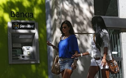 Dos mujeres pasan ante un cajero de Bankia.