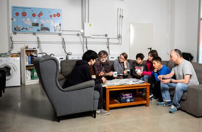 Familias de La Chalmeta en la sala común. Detrás de los sofás, las lavadoras que comparten algunos de los socios.