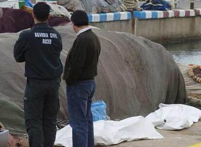 Responsables de los cuerpos de seguridad vigilan los cuerpos de las hermanas fallecidas.