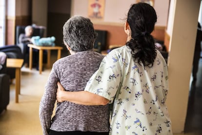 Una cuidadora acompaña a una persona mayor en una residencia geriátrica en un pueblo de la región.