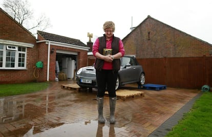 Carolyn Scriven de 57 años y agente de policía retirada, posa en su casa con una de las fotografías que rescataría si su casa se inundase.