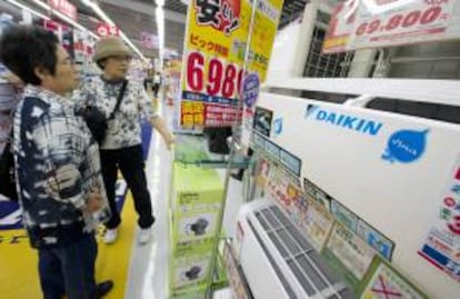 Dos mujeres miran aires acondicionados de la marca japonesa Daikin. EFE/Archivo