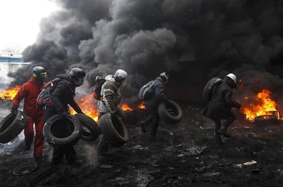 Manifestantes queman neumáticos para mantener la barricada que los separa de la policía antidisturbios en el centro de Kiev (Ucrania), 23 de enero de 2014.