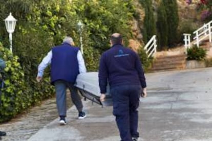 Efectivos de los servicios funerarios a su llegada al domicilio del matrimonio de jubilados que se ha suicidado en su vivienda de Cas Català, en el municipio mallorquín de Calvià, después de recibir el aviso de que iban a ser desahuciados del domicilio por impago.