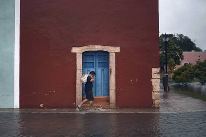 Un hombre camina por una calle inundada en Yucatán.