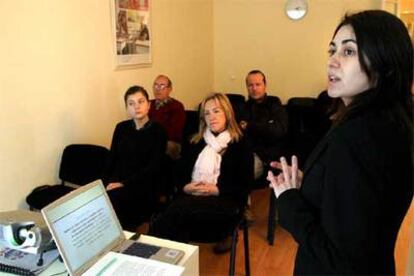 Un grupo de personas sigue las explicaciones de una escuela de padres de Barcelona.