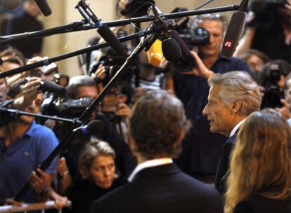 Dominique de Villepin (derecha) habla ante los periodistas a su llegada al tribunal de París donde está siendo juzgado.