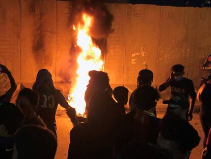 Manifestantes iraquíes prenden fuego a las afueras del consulado iraní, durante las protestas en Kerbala.