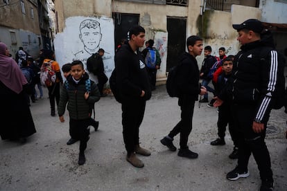 Niños a la salida del colegio en el campo de refugiados de Aida. Al fondo, mural con la imagen de un adolescente muerto por balas del ejército de Israel el pasado noviembre. 