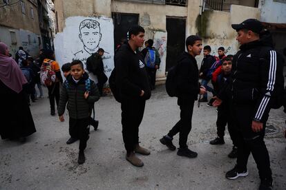 Niños a la salida del colegio en el campo de refugiados de Aida. Al fondo, mural con la imagen de un adolescente muerto por balas del ejército de Israel el pasado noviembre. 