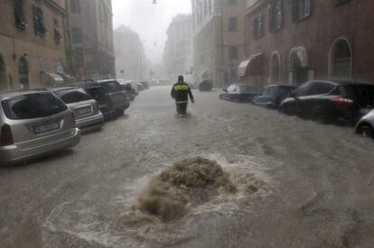 Un bombero trata de caminar en una calle inundada en G&eacute;nova (Italia)