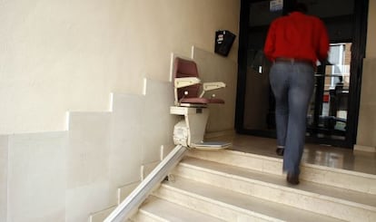 Silla mecánica para salvar las escaleras instalada en el acceso a una finca en Madrid.