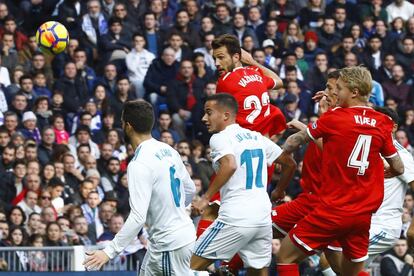 El centrocampista argentino del Sevilla Franco Damián Vázquez (3i) disputa un balón con los jugadores del Real Madrid Nacho Fernández (i) y Lucas Vázquez (3d).