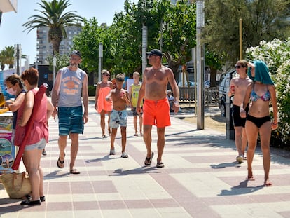 Un grupo de turitas pasea por el paseo marítimo de la playa s’Abanell,  en Blanes (Costa Brava).