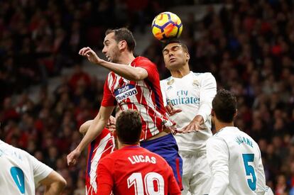 El centrocampista brasileño del Real Madrid Carlos Casemiro (d) pelea un balón con el defensa uruguayo del Atlético de Madrid Diego Godín.