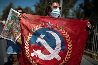 Una mujer muestra una bandera del Partido Comunista de Chile.