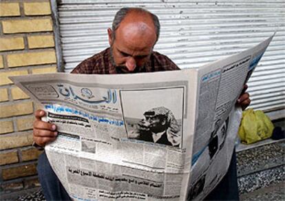 Un iraquí lee un periódico ayer en una calle de Bagdad.
