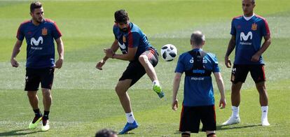 Diego Costa golpea el balón ante Koke, Thiago e Iniesta.