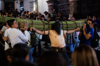 Hombres cargan rollos de varas de zarza con espinas en sus hombros y caminan con cadenas atadas en los pies y manos durante la Procesión del silencio en Taxco (México).