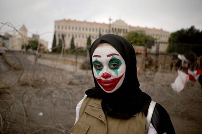 Una mujer libanesa con la cara pintada del personaje del Joker participa en una protesta en el centro de Beirut para exigir mejores condiciones de vida.