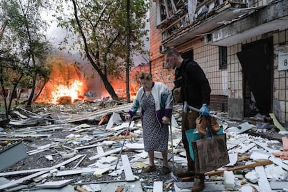 Varias personas inspeccionan los daños causados por el ataque aéreo ruso en Kiev este jueves.