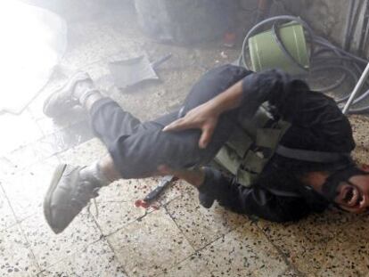 Un combatiente del Ejército Libre de Siria se duele de una pierna tras ser alcanzado por la metralla en el barrio de Saladino.