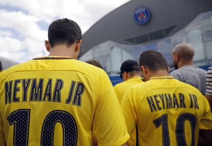 Personas esperan la llegada de Neymar a la rueda de prensa de su presentación, en París.