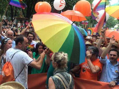 Un miembro del equipo de Ciudadanos, con un paraguas delante de Inés Arrimadas, durante el Orgullo.