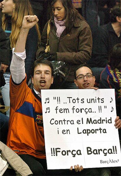 Dos aficionados del Barcelona muestran una pancarta de descontento con Laporta.